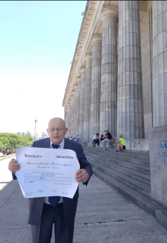 Frente a las escalinatas de la Facultad de Derecho de la Universidad de Buenos Aires, sosteniendo su papel más preciado